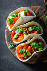 Spicy tacos with fresh coriander on concrete table