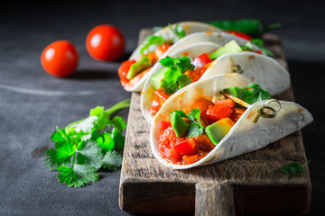 Mexican tacos with tomato sauce and avocado on concrete table
