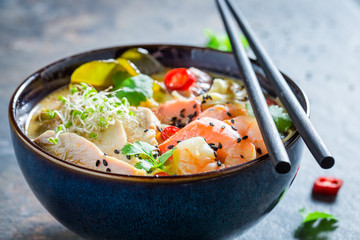 Malaysian Soup with coconut milk and prawn on concrete table