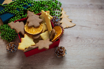 Tasty Homemade Christmas Cookies in Red Box with Festive Decoration on a Wooden Background.