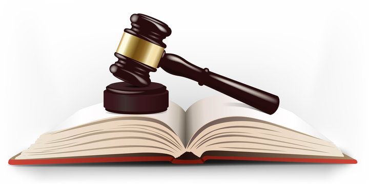 Maillet de juge posé sur un livre de lois pour symboliser la justice et le système judiciaire.