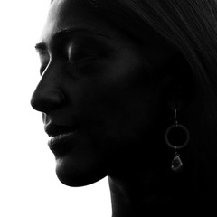 Close up portrait of a young, ethnic girl with strong features highlighting her silhouette, black and white
