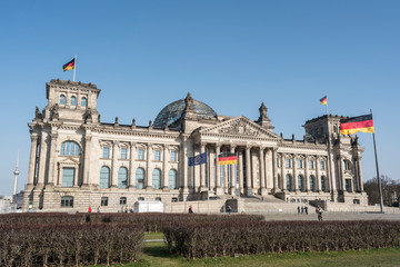 The facade of Reichstag building in Berlin, many unidentified visitors and tourists in foreground.