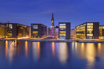Fototapeta na wymiar Church Christians Kirke and waterfront with its mirror reflection in canal at night, Copenhagen, capital of Denmark