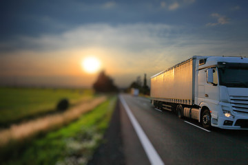 Truck transport on the road at sunset