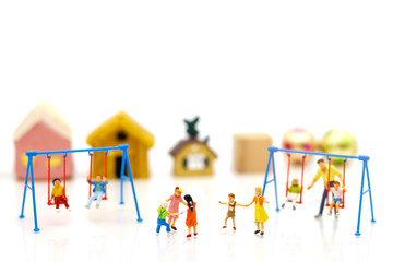 Miniature people, children and family enjoy with swing , happy family day concept.