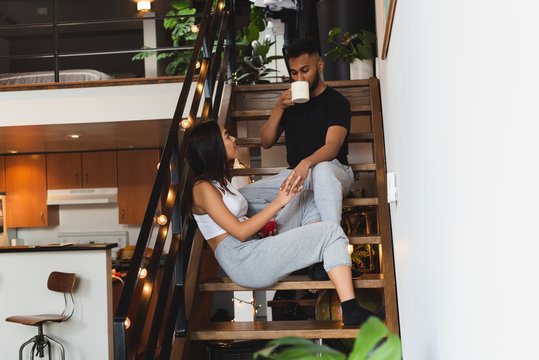 Couple interacting with each other while having coffee in stairs