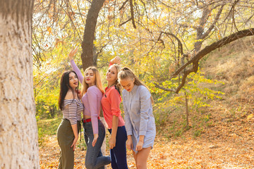 Fototapeta premium Summer autumn vacation, holidays, travel and people concept - group of young women in the park