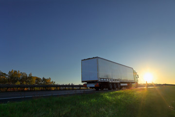 Truck transport on the road at sunset