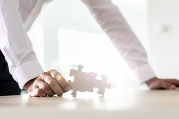 Businessman holding two matched puzzle pieces