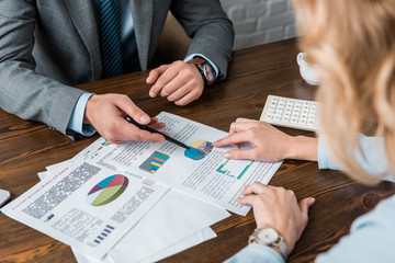 cropped shot of business people working with charts and graphs in office