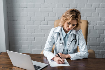 confident female doctor writing document at workplace in office