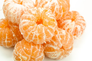 bunch of peeled tangerines or mandarins on a white table