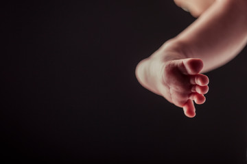 pie de bebé recién nacido sobre fondo negro