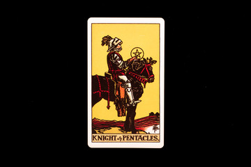 An individual minor arcana tarot card isolated on black background. Knight of pentacles.