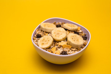 A bowl with banana, oats and cereal.