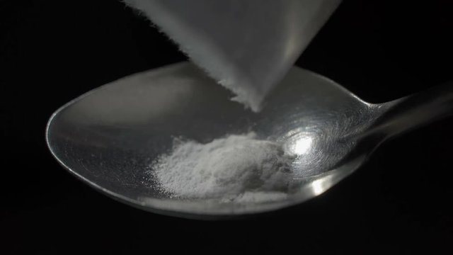 Lighter heating a spoon of heroin. Close up.