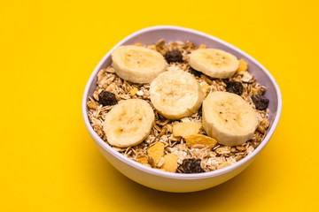 A bowl with banana, oats and cereal.