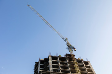 Fototapeta na wymiar Construction crane with high-rise building under construction