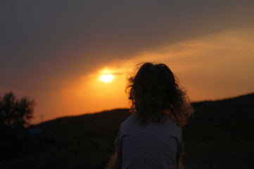 silhouette of girl on top of mountain at sunset