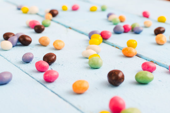 Multicolored candies scattered on a wooden table