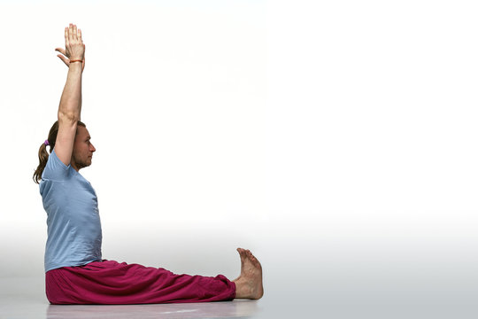 Bearded longhair man practicing yoga. Model doing exercises isolated on white background. Dandasana pose. Full length