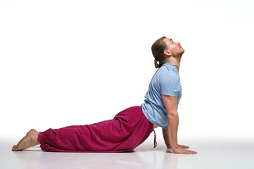 Bearded longhair man practicing yoga. Model doing exercises isolated on white background. Bhudjangasana pose. Full length
