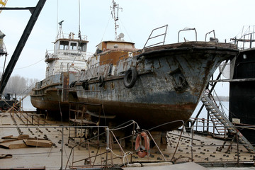 Archive 2008 River port of Ust-Danube was destroyed in of crisis. Old rusty boats on stocks in dry dock of river port. Old river vessels rust on dock repair shop stocks for repair of river vessels