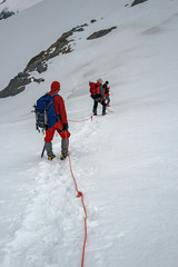Some climbers on roped during an excursion on a glacier in the Alps.