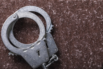 Top view of the handcuffs in left side of stone surface with copy space