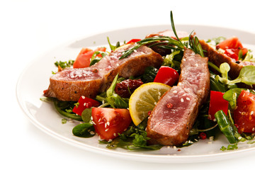 Fillet mignon - grilled beefsteaks with vegetables on white background