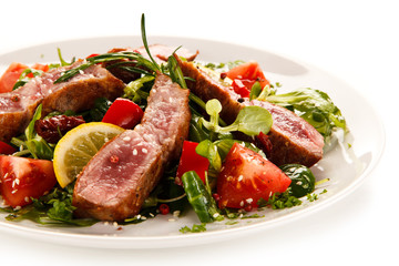 Fillet mignon - grilled beefsteaks with vegetables on white background