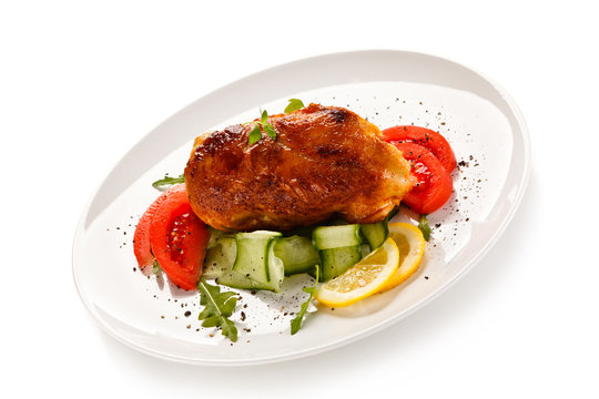 Grilled chicken fillet with vegetables on white background