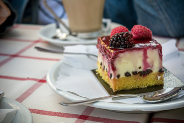 Piece of Cheese Cake With Strawberries, Chocolate and Cream upon a Table of Italian Bar