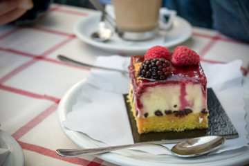 Piece of Cheese Cake With Strawberries, Chocolate and Cream upon a Table of Italian Bar