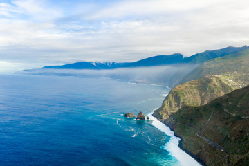 Aerial Madeira island view with Atlantic ocean, white waves, cliffs and green nature