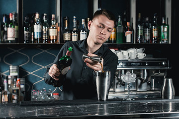 bartender making Boulevardier Cocktail pouring fluid into glass. Bar on a background