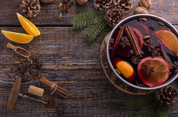 Ingredients for traditional winter drink with red mulled wine, species, orange, lemon on a wooden...