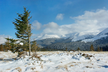 Winter mountain landscape with snow and blue sky with clouds. The dominant winds in the mountains