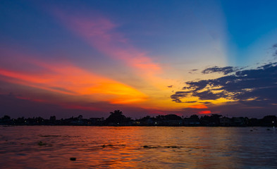 landscape of the Chao Phraya River and the colorful sunset sky. Light blue and orange