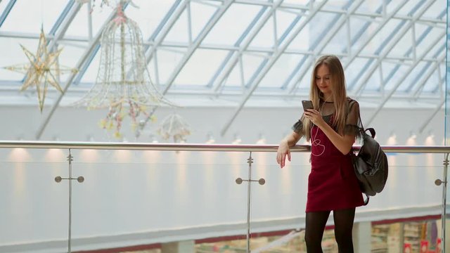 Smiling female blogger listening favorite songs in headphones while posing for selfie on smartphone camera, hipster girl enjoying radio broadcast making photo for picture in social networks on mobile.
