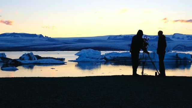 Silhoutte of a man filming the Glacier lagoon in Iceland at sunset