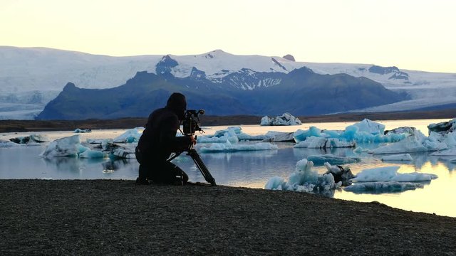 Silhoutte of a man filming the Glacier lagoon in Iceland at sunset