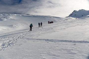 Some snowshoe hikers walk through the snow-covered Alps in winter in the canton of Graub&uuml;nden in Switzerland.