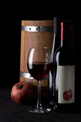 Still life with pomegranate wine on a black background