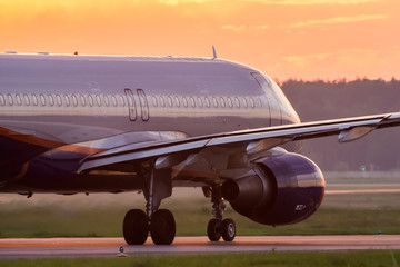 Fototapeta na wymiar Modern twin engine civil airplane taxiing for take off at International airport during sunrise.