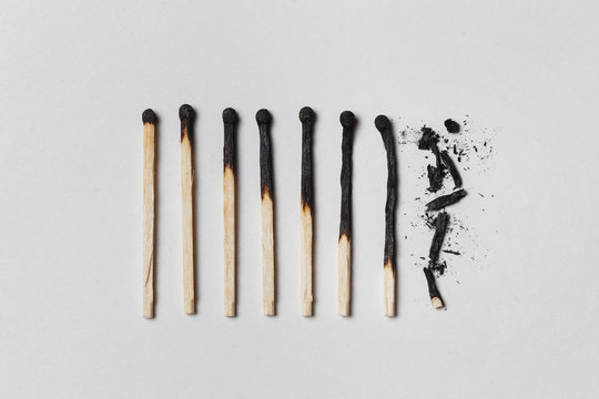 Concept of patience. A row of burnt matches, from left to right, from almost a whole match to a completely burnt match to the dust.