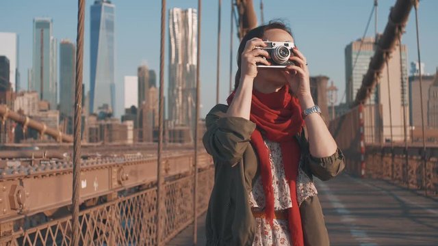 Attractive tourist with a retro camera on a bridge