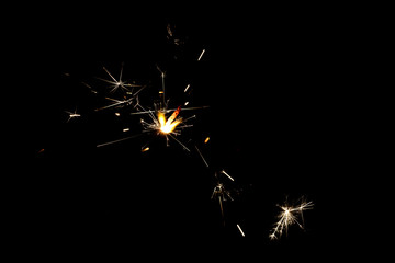 Yellow spark of sparkler on black background