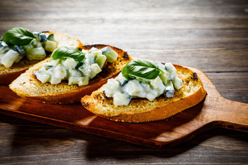 Bruschettas on cutting board on wooden background